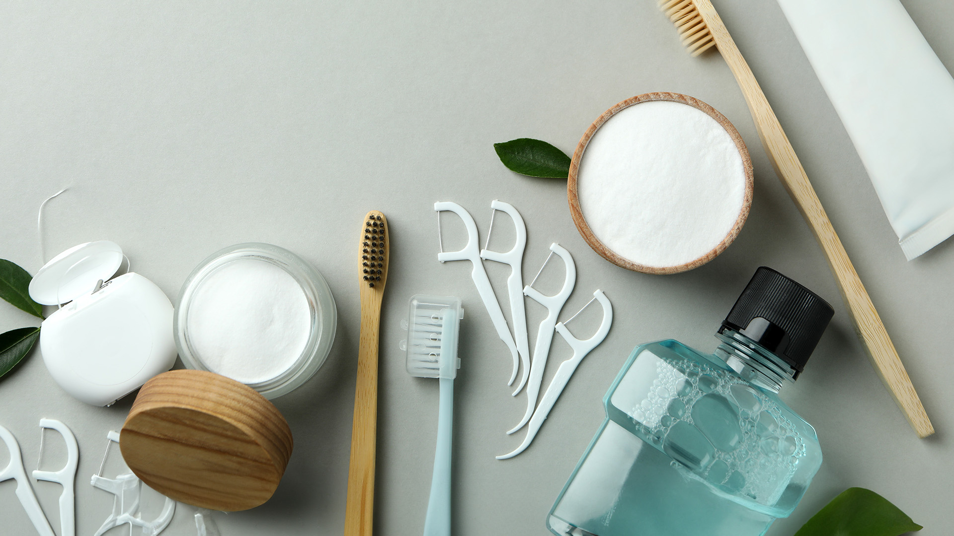 The image shows a collection of skincare products displayed on a surface with various brushes and items related to skincare, including jars, creams, toothbrush heads, and other beauty supplies.