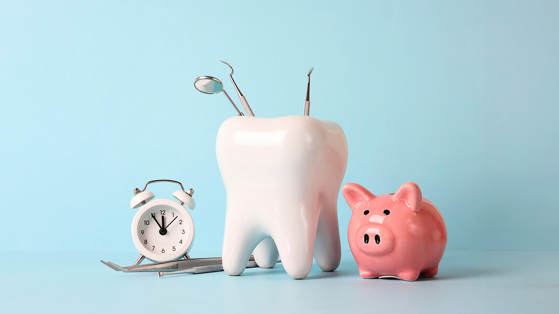 The image features a collection of playful dental-themed items on a light blue background, including a piggy bank, toothbrush holder, toothpaste tube, and other dental care accessories.