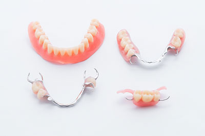 The image shows a set of clear dental retainers with teeth-like attachments on a white background, presented in a collage format with variations in positioning.