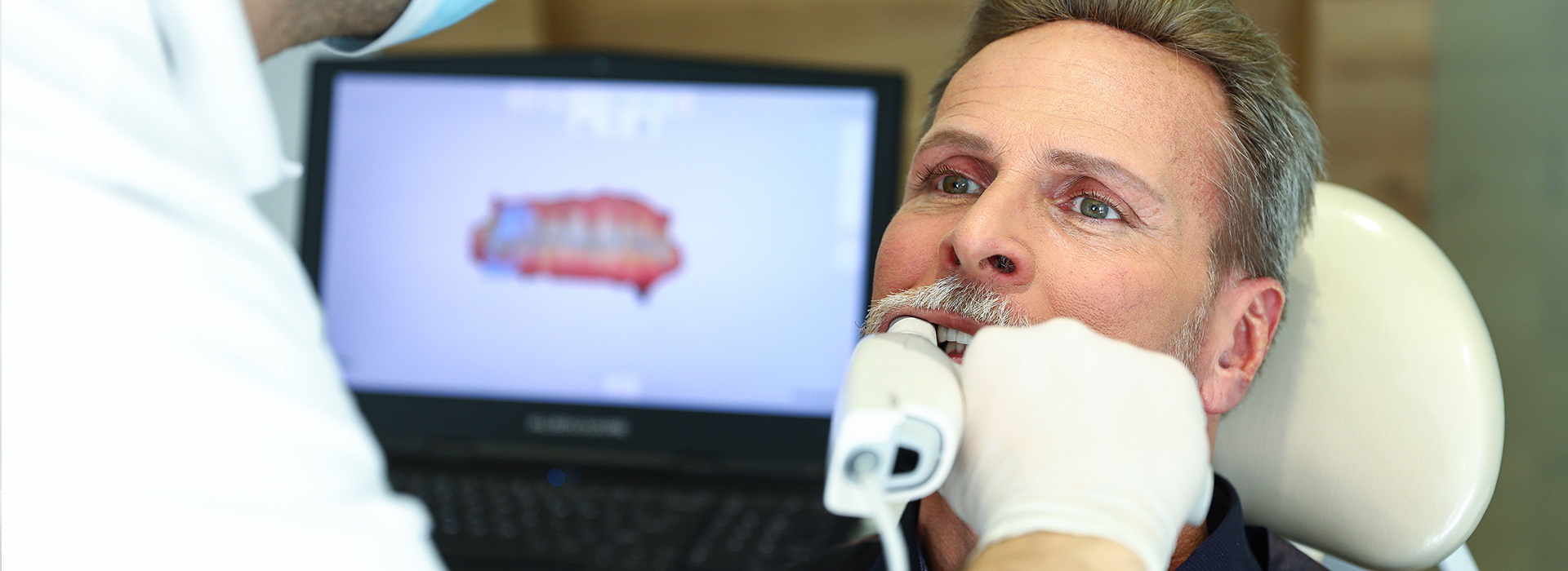 A person receiving dental treatment, with a focus on a device being used by a professional.