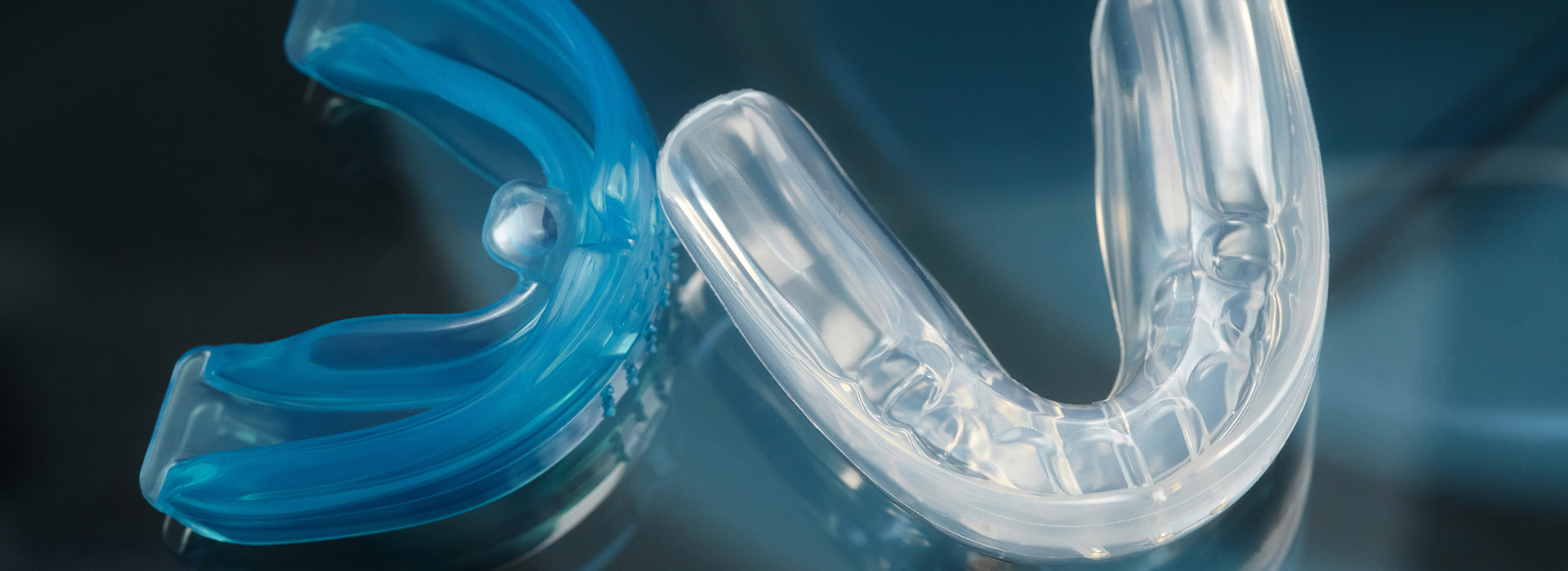 Clear blue plastic braces with metal clasps against a blurred background.